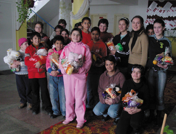 Adriana (third from right, standing) and orphan girls with donated gifts at Floare de Colt (Noble Flower).