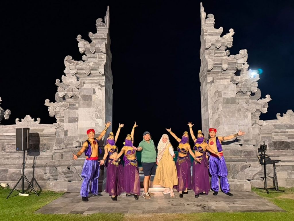 Posing with members of a Balinese art troupe performing at a luxury hotel.